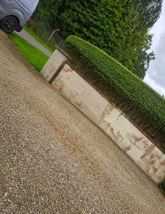 Gravel driveway and trimmed hedge line after a garden tidy-up